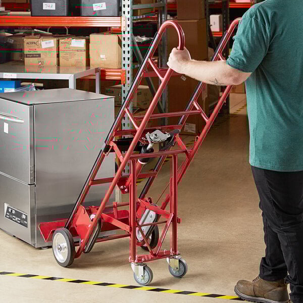 A man holding a Lavex Steel Appliance Hand Truck in a warehouse.