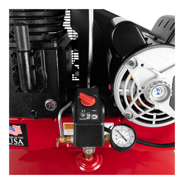 A red Powermate stationary air compressor with a gauge.
