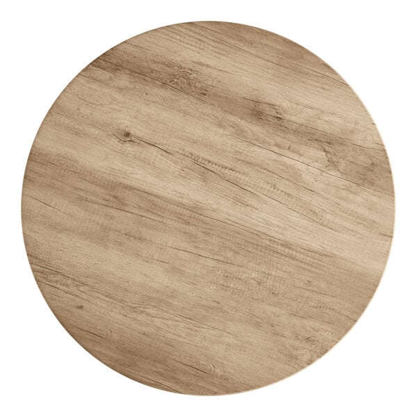 A Lancaster Table & Seating round wood table top with a gray wood finish.