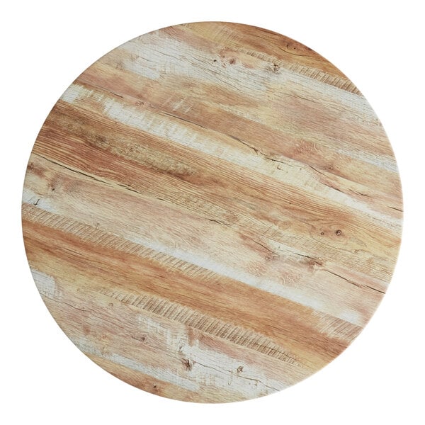 A Lancaster Table & Seating round wood table top with a barnwood finish.