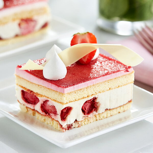 A piece of White Toque strawberry strip cake with strawberries and whipped cream on a plate.