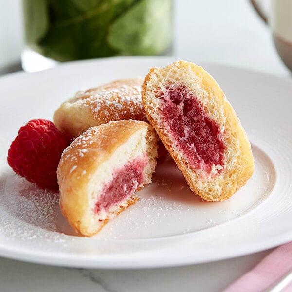 A white plate with White Toque raspberry filled mini beignets.