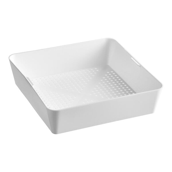 A white square plastic floor drain strainer with holes.