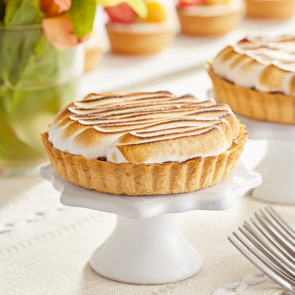 Two Pidy Gourmet sweet butter tart shells with meringue on top of them.