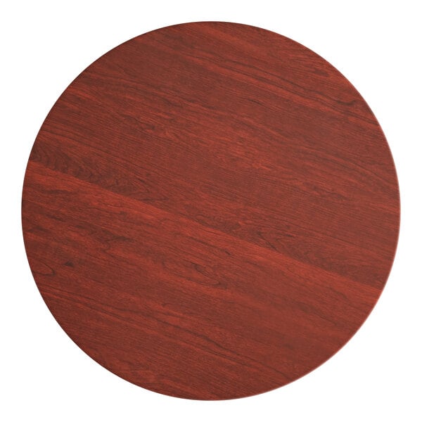 A Lancaster Table & Seating round wooden table top with a red mahogany finish.