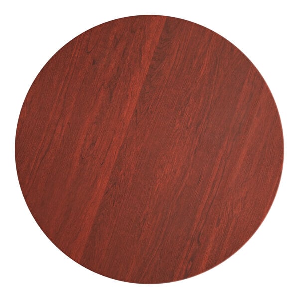 A Lancaster Table & Seating round wood table top with a red mahogany finish.
