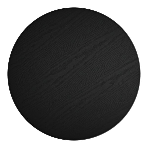 A black circular table surface with a white object in the middle.