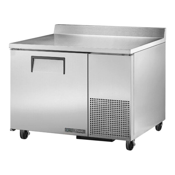 A large stainless steel True worktop freezer on wheels.