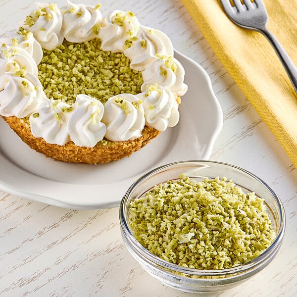 A bowl of White Toque granulated lime zest next to a plate of pie with whipped cream and green toppings.