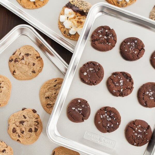 A Nordic Ware 3-piece rimmed sheet pan set with trays of chocolate chip cookies.