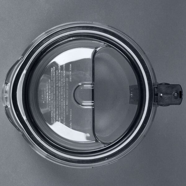 A clear plastic Waring batch bowl cover with a black handle.