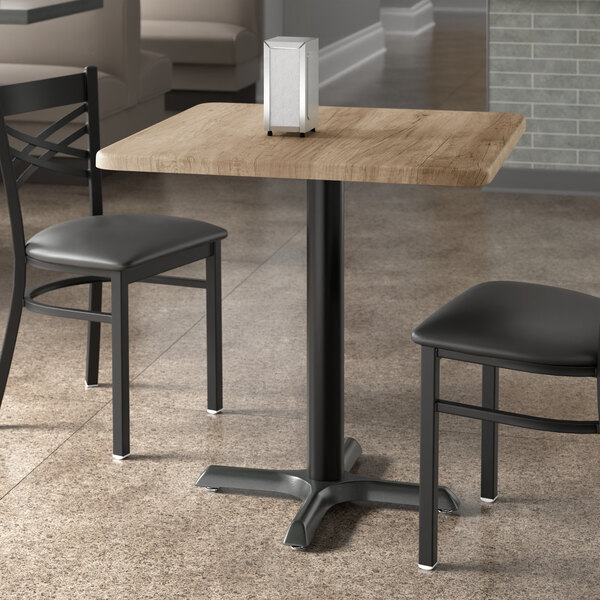 A Lancaster Table & Seating square table with gray wood finish and two chairs.