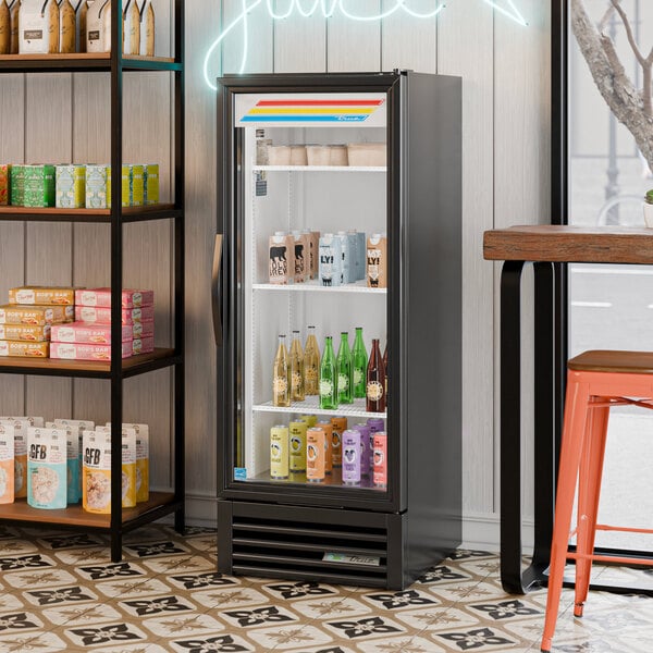 A black refrigerated glass door merchandiser with LED lighting, stocked with various beverages.
