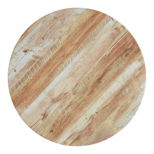 A Lancaster Table & Seating round wood table top with a barnwood finish.