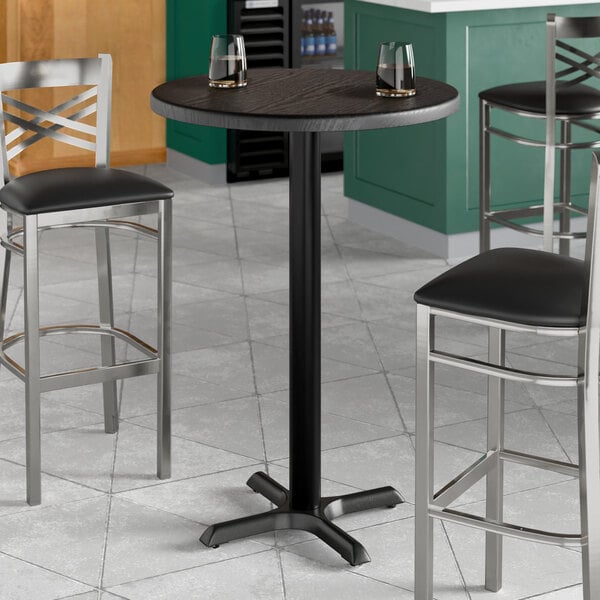 A Lancaster Table & Seating round bar height table with black wood finish and a black pole with a black top.