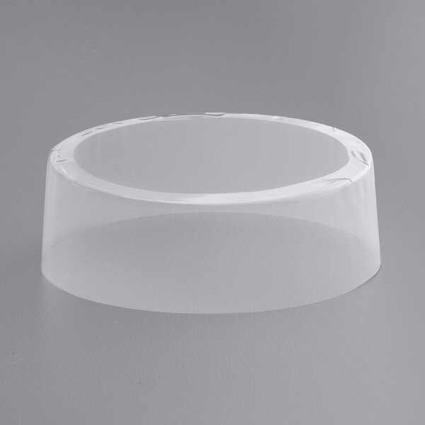 A clear plastic container with a white circle on a gray surface.