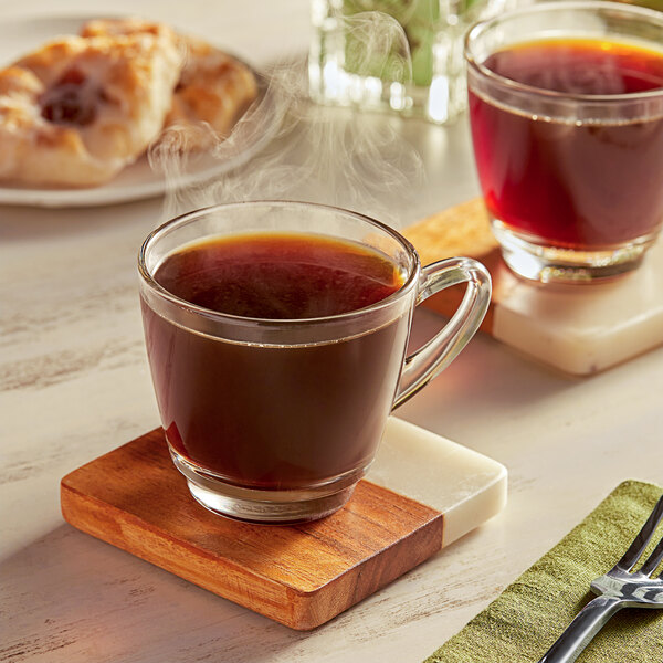 A couple of illy coffee cups on a wooden coaster.