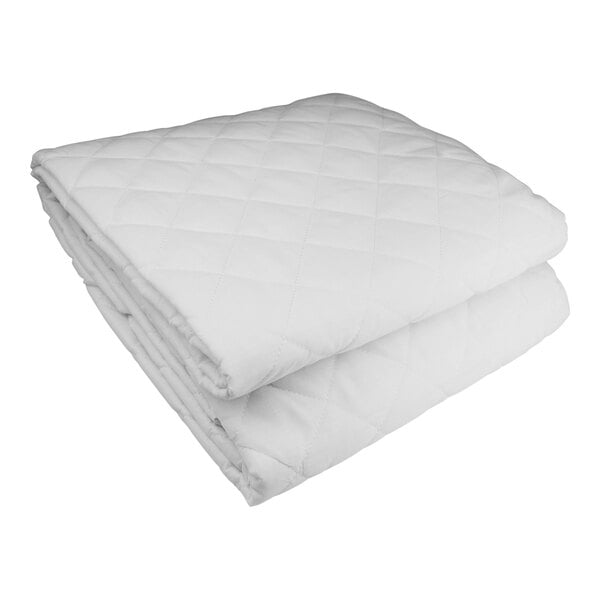 A close-up of a stack of white Oxford King Size quilted mattress pads.