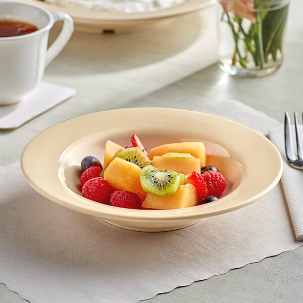 A bowl of fruit in a tan melamine bowl.