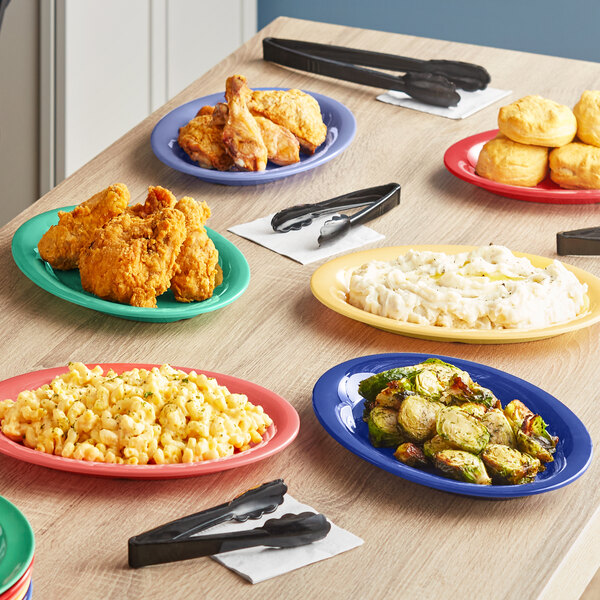 An Acopa Foundations assorted color melamine platter on a table full of food.