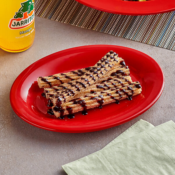 A plate of churros with chocolate sauce on a red Acopa Foundations melamine platter.