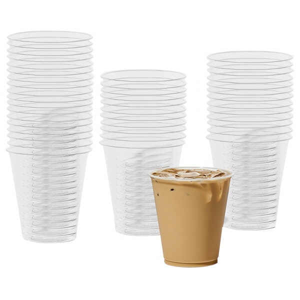 A stack of Tossware clear plastic cups with a drink in one cup.