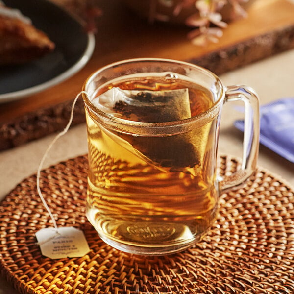 A glass mug of Harney & Sons Paris tea with a bag in it.