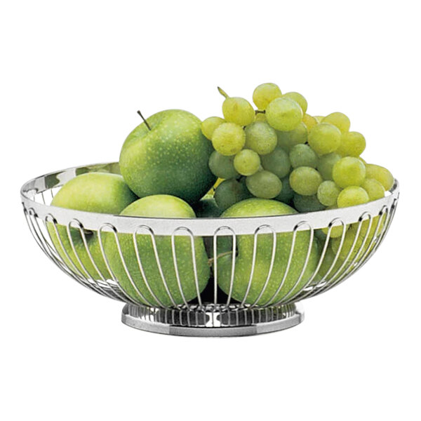 A close-up of a Hepp by Bauscher stainless steel fruit basket filled with green apples and grapes.