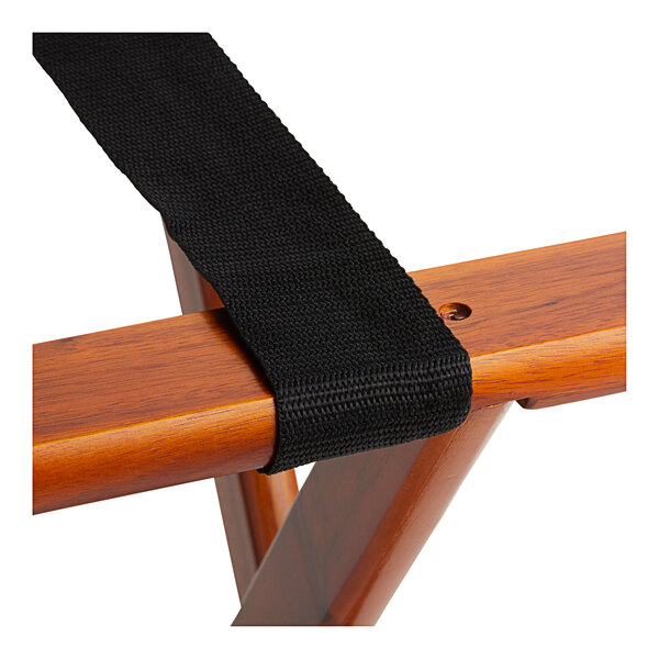 A black strap on a Lancaster Table & Seating walnut wood folding luggage rack.