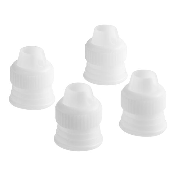 Four white plastic Wilton couplers with caps.