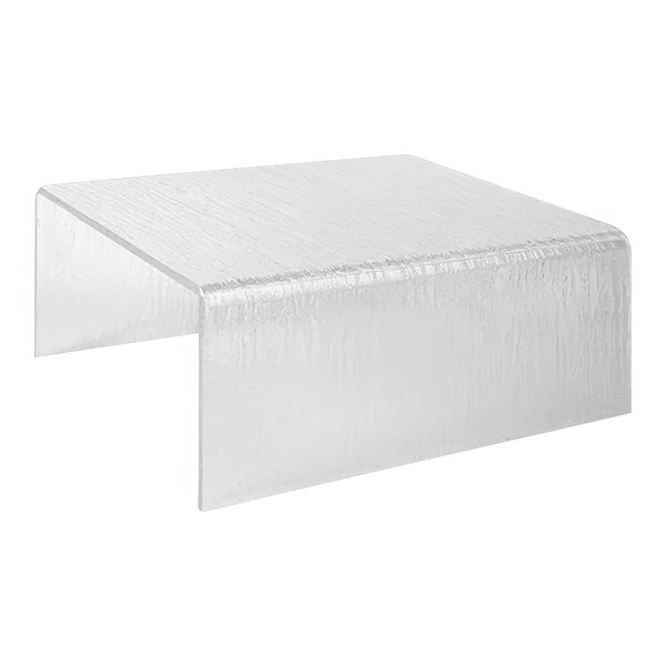 A Dalebrook clear textured acrylic riser on a clear table with a white background.