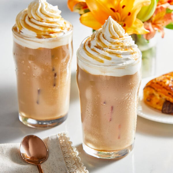 Two iced coffee drinks with whipped cream and Guittard caramel sauce.