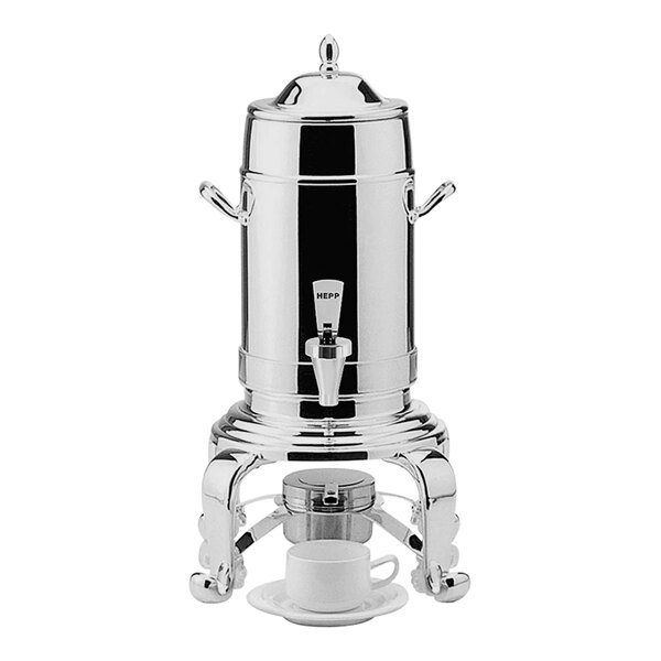 A Hepp stainless steel coffee urn with a white cup on a saucer.