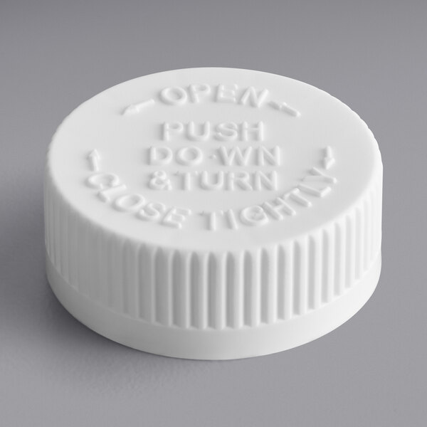 A 38/400 white plastic child-resistant cap with foam liner and the words "push down and close" on it.