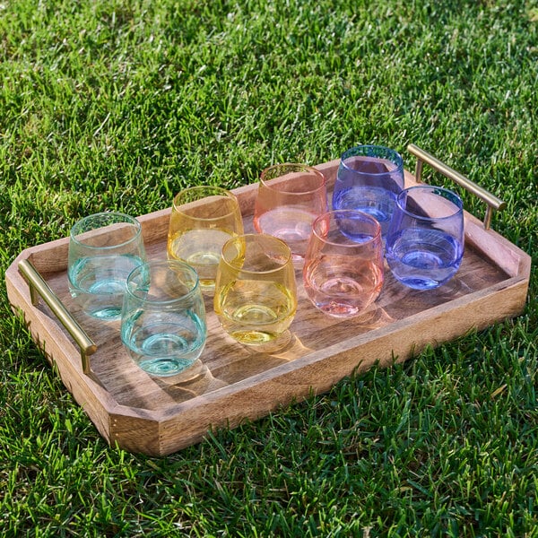 A tray of Tossware lemon yellow vino glasses on a table.