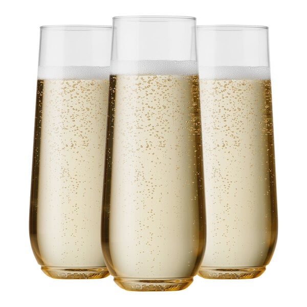 Tossware plastic champagne glasses filled with champagne.