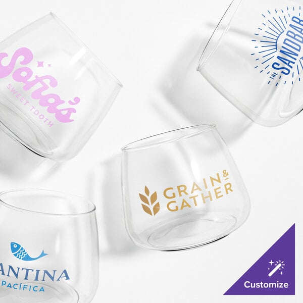 A close up of four Tossware Rocks Glasses with different logos on them.