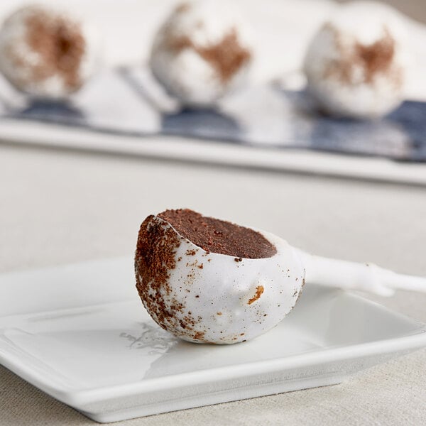 A Coco Bakery Cookies and Cream cake pop on a plate.