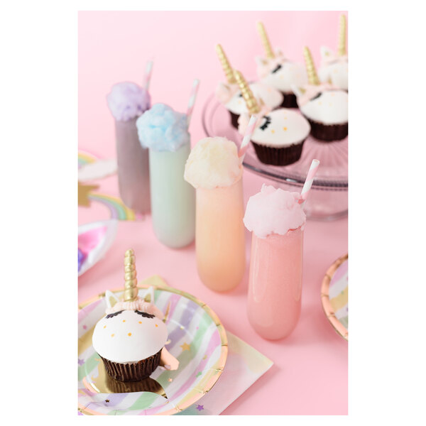 A Tossware plastic champagne flute with a cupcake on top with a unicorn horn.