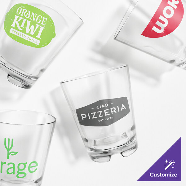 A Tossware Reserve rocks glass with a green and white logo.