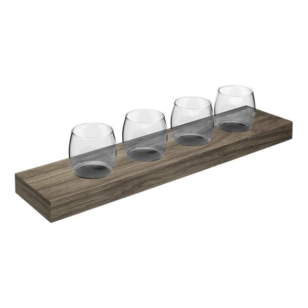 A row of Tossware POP Taster glasses on a wooden flight tray.