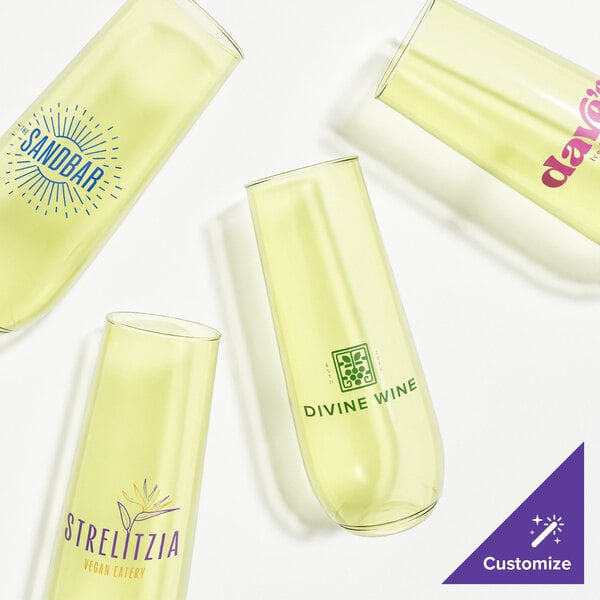 Three Tossware lemon yellow plastic champagne flutes with different designs on them.