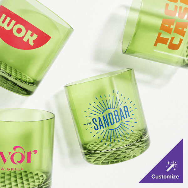 A close-up of four green Tossware Rocks glasses with different designs.