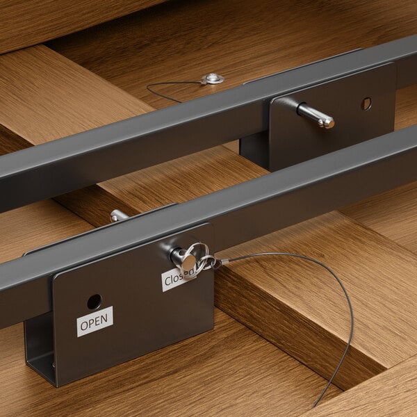 A Lancaster Table & Seating Vineyard Series brown round folding table with metal bars attached to it.