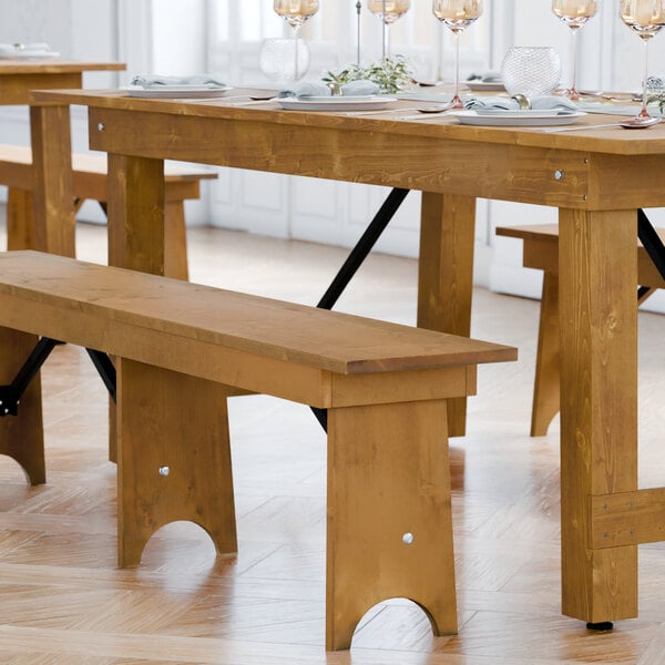 A Lancaster Table & Seating Vineyard Series brown wooden folding bench with a barrel backrest.