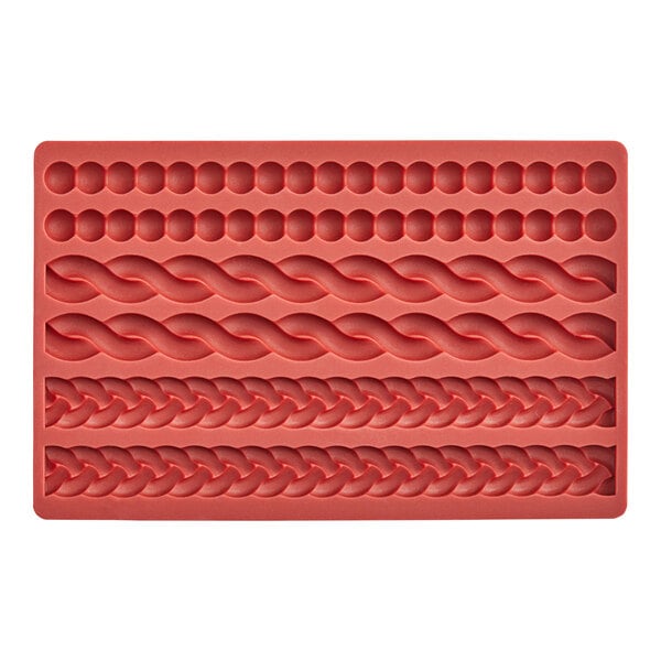 A close-up of a red Wilton silicone mold with different curved patterns.