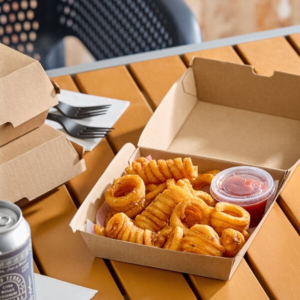 A brown corrugated clamshell container filled with curly fries and a small cup of ketchup.
