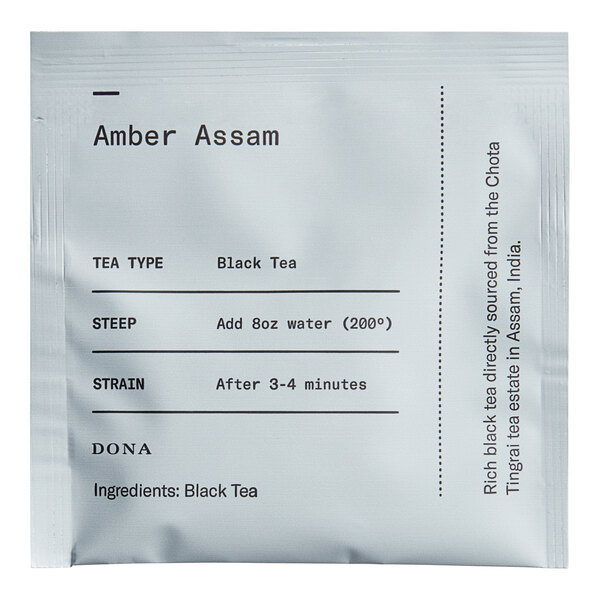 A white Dona Amber Assam Tea packet with black text.