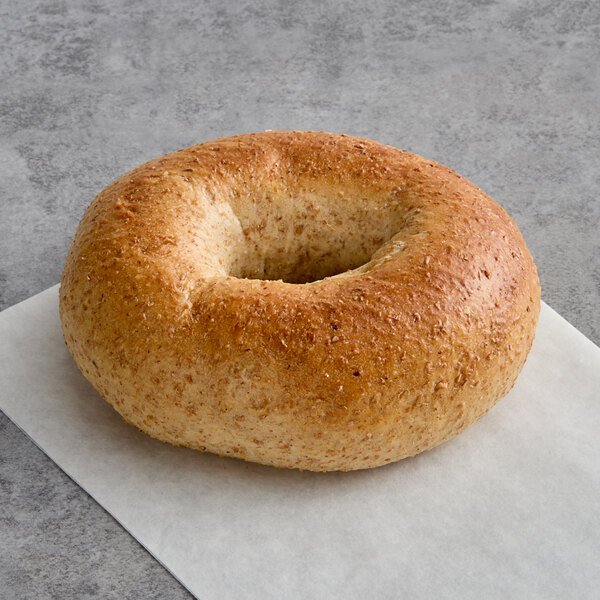 A Just Bagels wheat bagel on a white surface.