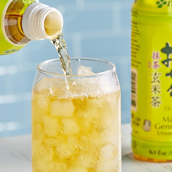 A bottle of Ito En Oi Ocha Matcha Genmaicha Green Iced Tea being poured into a glass.